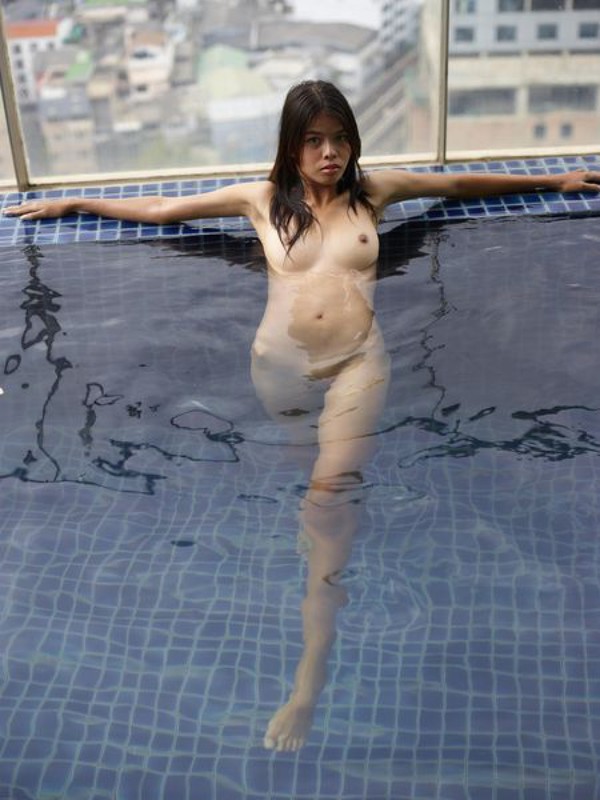 Азиатская девушка шалит в бассейне и на шезлонге 5 фото